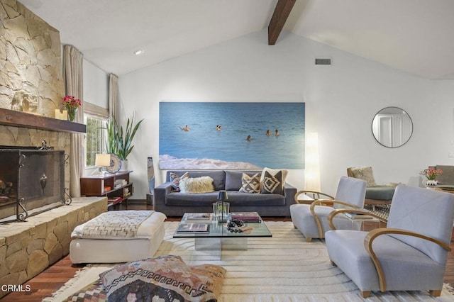 living room with wood finished floors, vaulted ceiling with beams, and visible vents