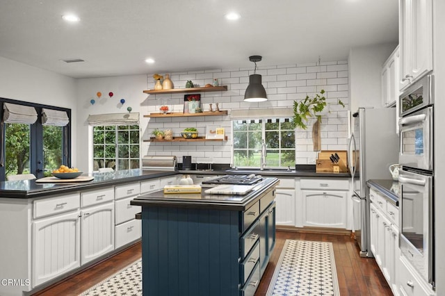 kitchen with white cabinets, dark countertops, and backsplash
