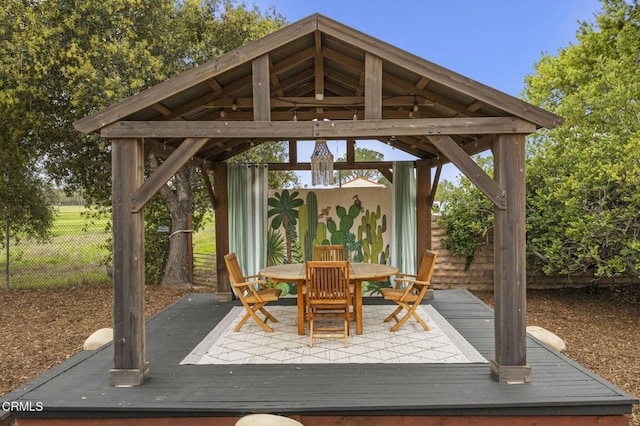 exterior space featuring outdoor dining area, a gazebo, fence, and a deck