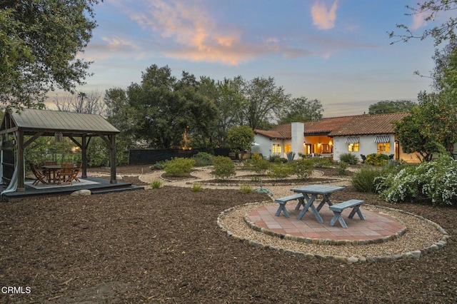 yard at dusk featuring a gazebo and a patio area