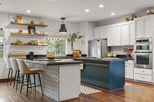 127 Fairway Ln, Ojai, CA 93023 - kitchen featuring dark wood-style floors, white cabinetry, dark countertops, and appliances with stainless steel finishes