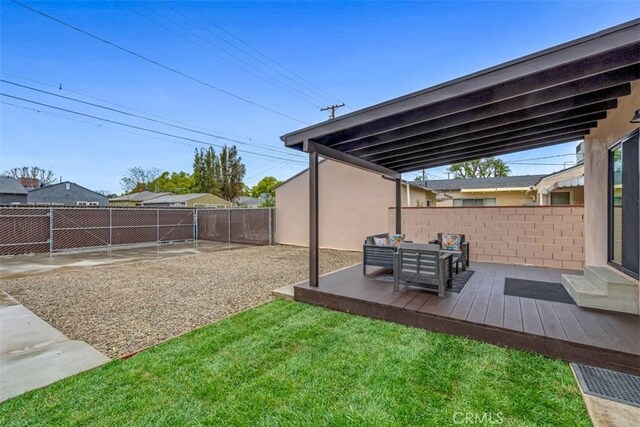 view of yard with an outdoor living space, a fenced backyard, and a wooden deck