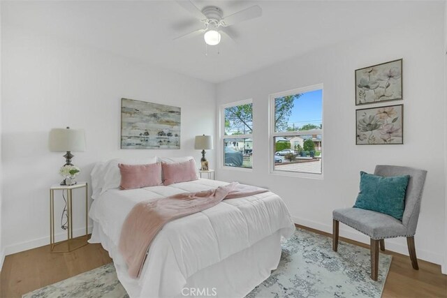 bedroom featuring baseboards, ceiling fan, and wood finished floors