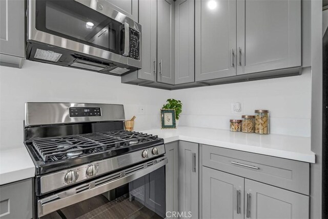 kitchen featuring light countertops, appliances with stainless steel finishes, and gray cabinets