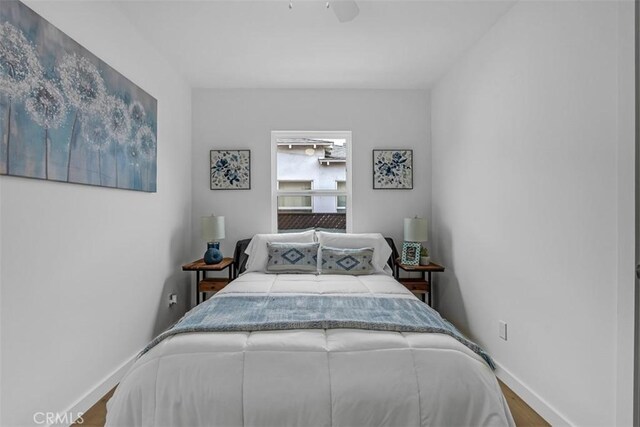 bedroom with baseboards, ceiling fan, and wood finished floors