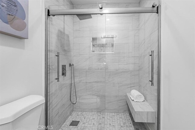 full bath with toilet and a marble finish shower