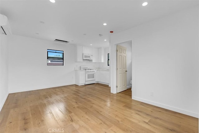 433 N Buena Vista St, Burbank, CA 91505 - unfurnished living room featuring light wood-style floors, recessed lighting, baseboards, and an AC wall unit