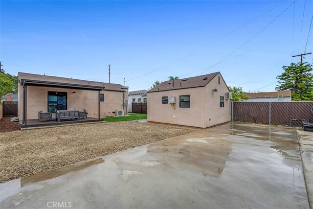 back of property with a fenced backyard, outdoor lounge area, a patio area, and stucco siding