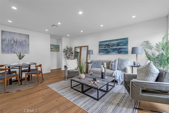 living area featuring visible vents, recessed lighting, and wood finished floors