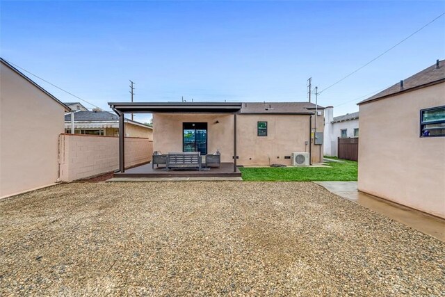 rear view of house featuring fence, ac unit, outdoor lounge area, and stucco siding