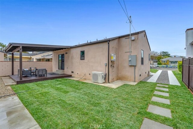 back of property with a lawn, ac unit, fence private yard, and stucco siding