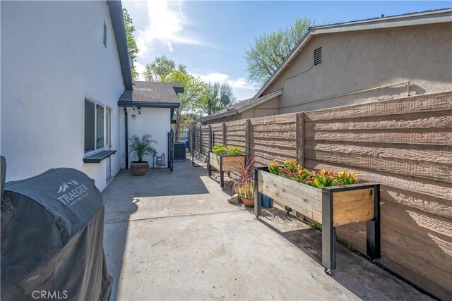 view of patio with a vegetable garden, area for grilling, and fence