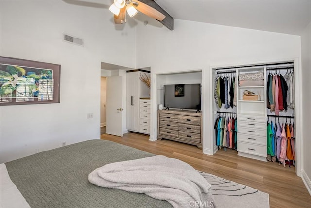 bedroom with visible vents, high vaulted ceiling, wood finished floors, and a ceiling fan