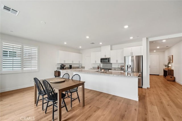 dining area with baseboards, visible vents, recessed lighting, and light wood finished floors
