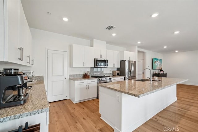 kitchen with white cabinetry, light wood-type flooring, visible vents, and appliances with stainless steel finishes