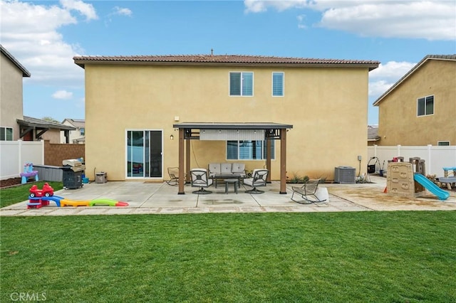 rear view of house with central AC unit, stucco siding, fence, and a yard