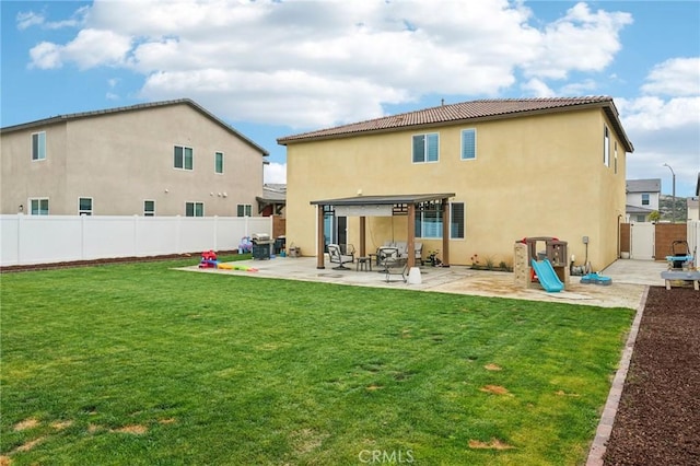 back of house with stucco siding, a fenced backyard, a lawn, and a patio area
