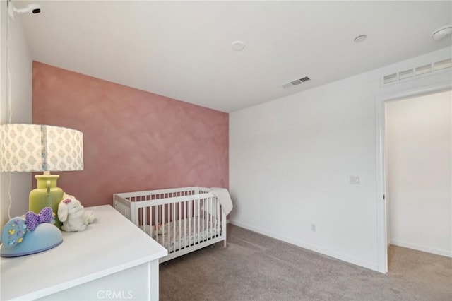 bedroom with baseboards, visible vents, carpet flooring, and a nursery area