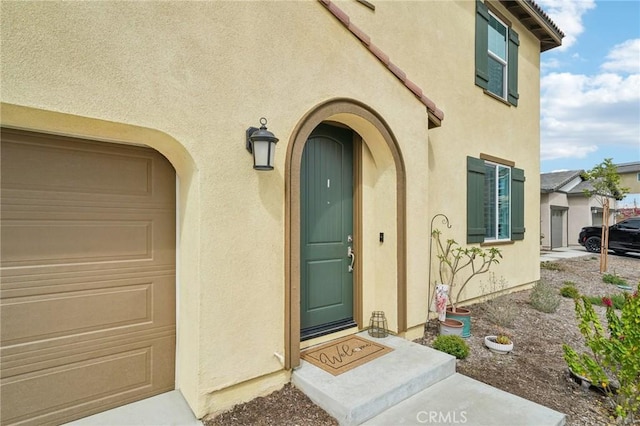 property entrance featuring stucco siding and a garage
