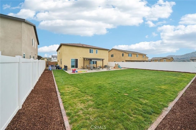 back of property with a fenced backyard, a lawn, stucco siding, and a patio