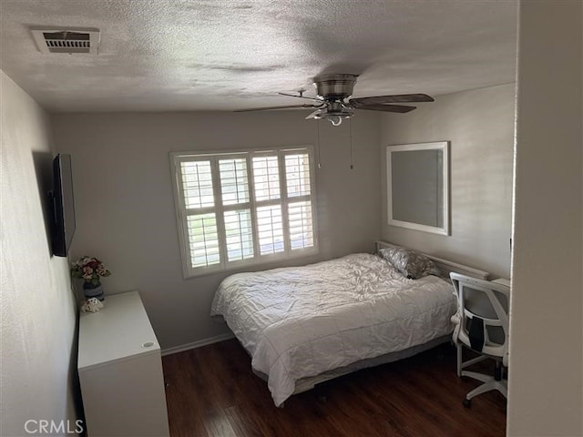 bedroom featuring a textured ceiling, visible vents, a ceiling fan, and wood finished floors
