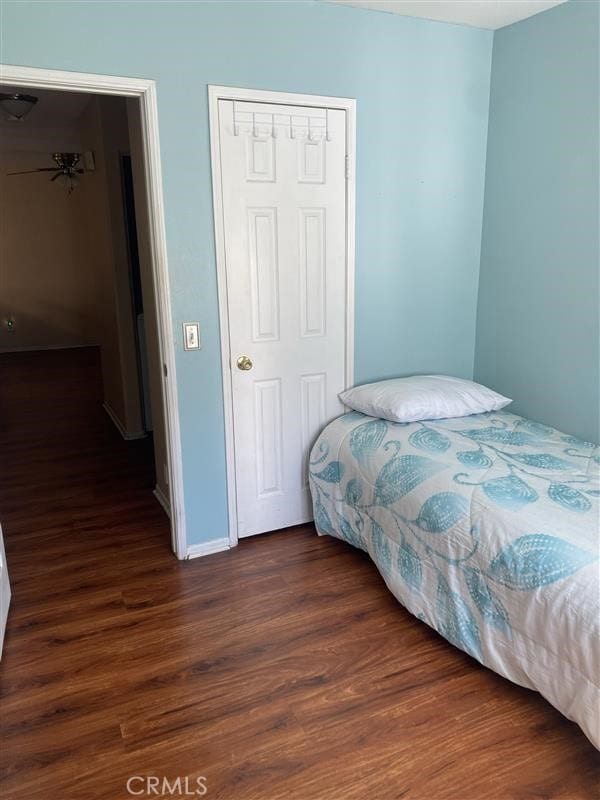 bedroom with dark wood-style flooring and a closet