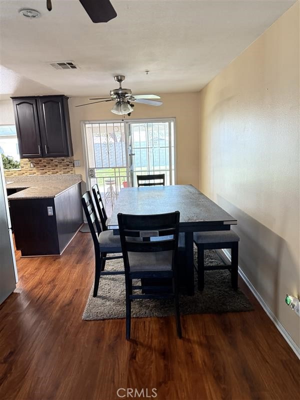 dining area with a ceiling fan, dark wood-style flooring, baseboards, and visible vents
