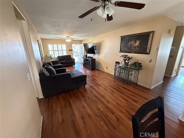living area with baseboards, wood finished floors, and ceiling fan