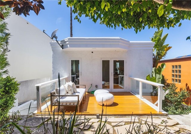 back of house featuring stucco siding, a wooden deck, and outdoor lounge area