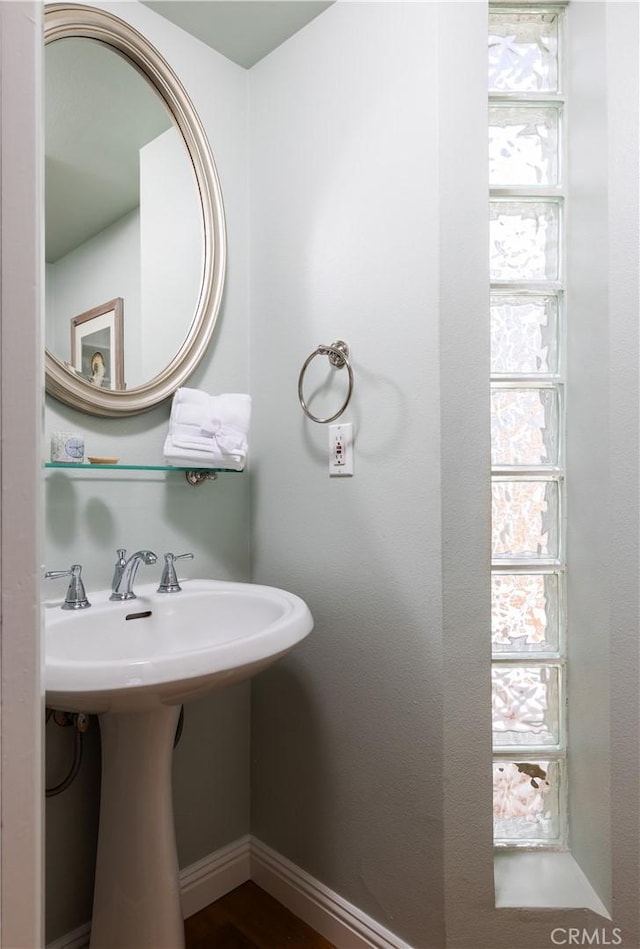 bathroom featuring baseboards and a sink