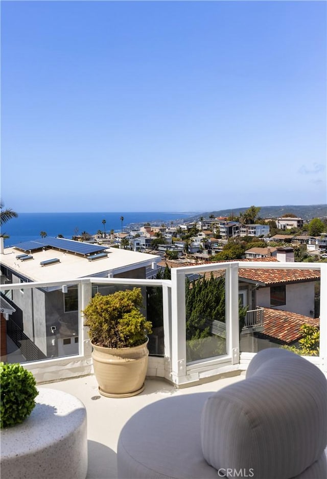 exterior space featuring a balcony and a water view
