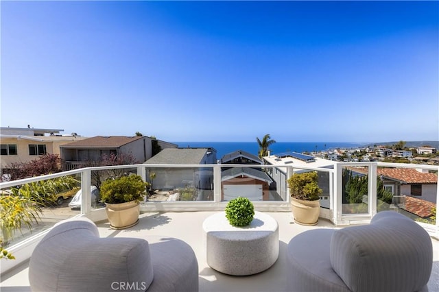 view of patio / terrace with a balcony and a water view