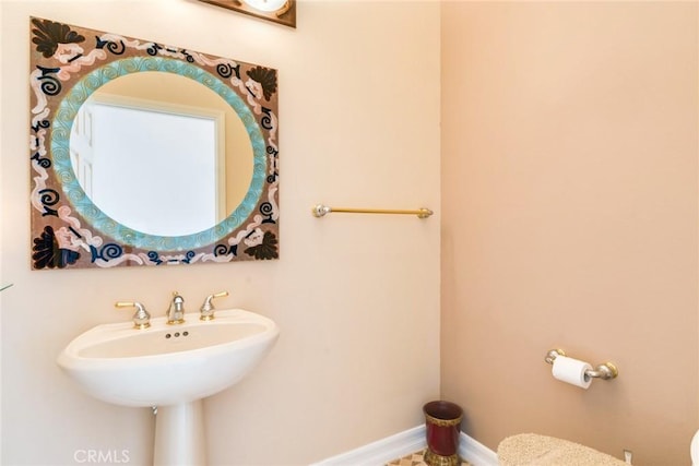 half bath with baseboards and toilet