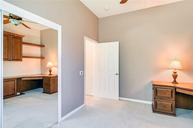 office area featuring baseboards, a ceiling fan, and light colored carpet