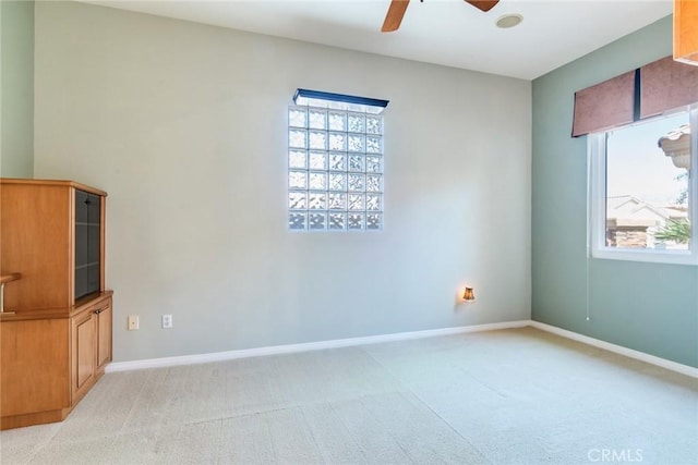 unfurnished room featuring light carpet, baseboards, and ceiling fan