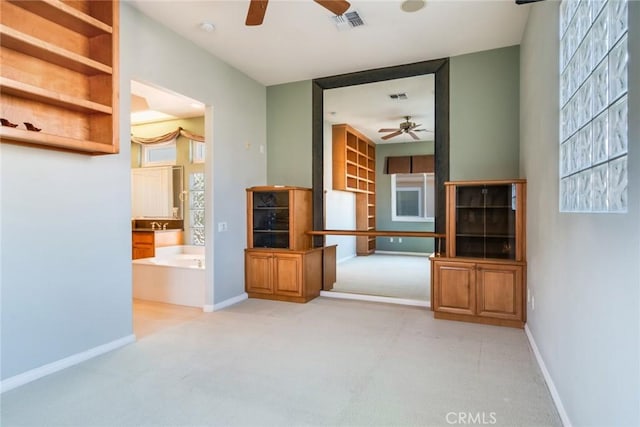 unfurnished living room with baseboards, ceiling fan, and visible vents
