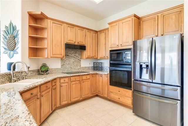 kitchen with light stone countertops, under cabinet range hood, a sink, open shelves, and black appliances