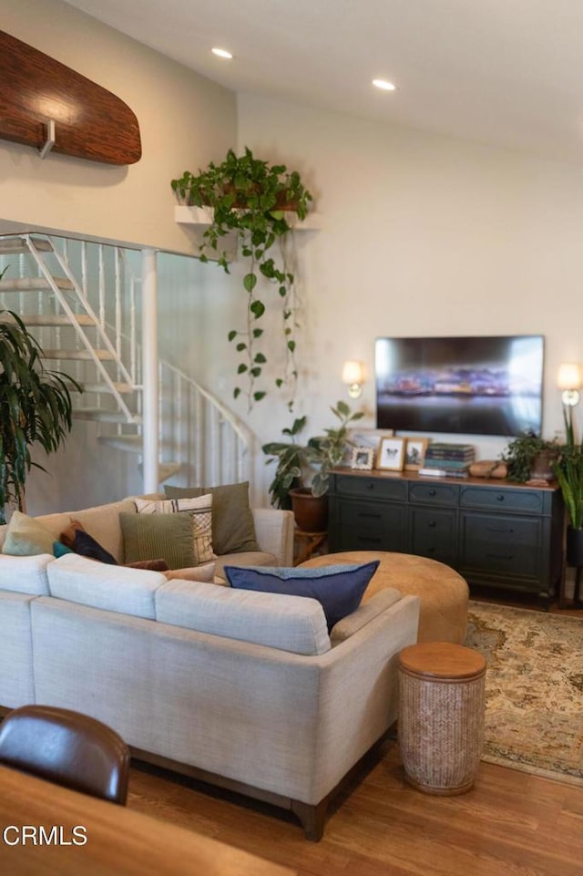 living room with recessed lighting, wood finished floors, and stairway