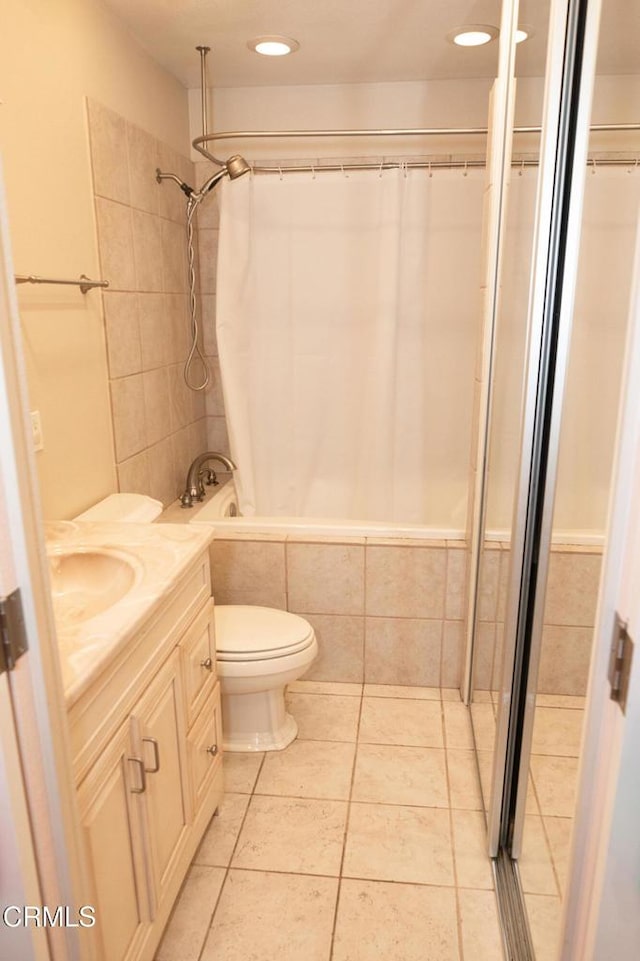 full bath featuring toilet, recessed lighting, vanity, tiled shower / bath, and tile patterned flooring