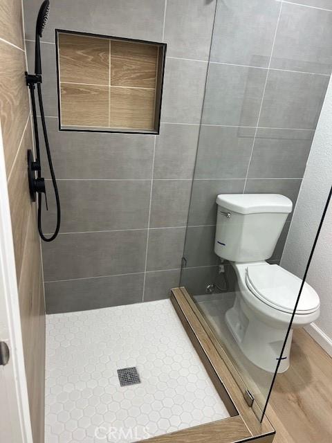 1197 Colony Dr, Pomona, CA 91766 - bathroom with a shower stall, toilet, and wood finished floors