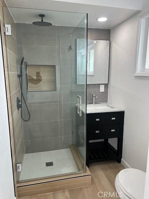 1197 Colony Dr, Pomona, CA 91766 - bathroom with toilet, a shower stall, vanity, and wood finished floors