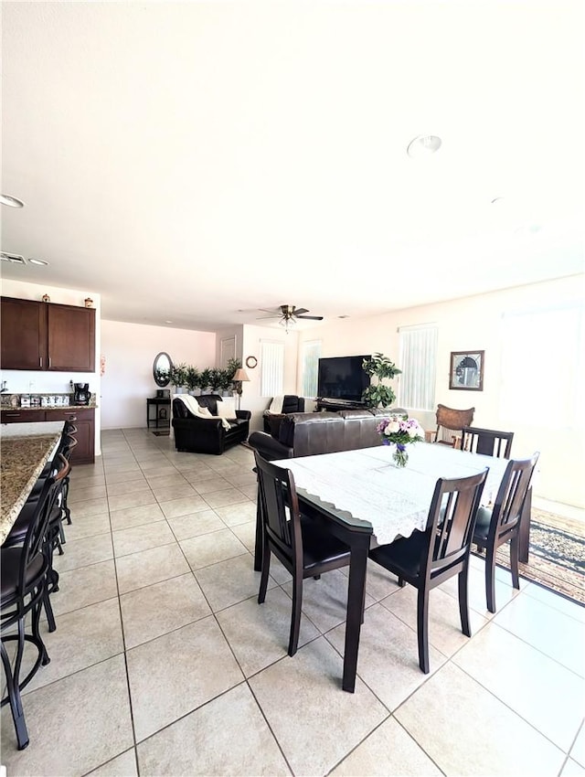 dining space featuring light tile patterned flooring and a ceiling fan