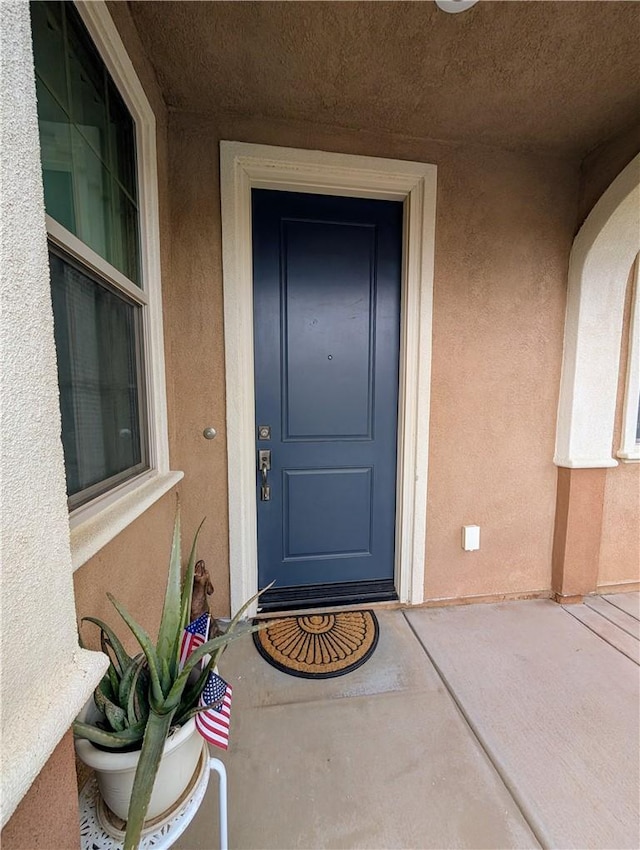 view of exterior entry featuring stucco siding