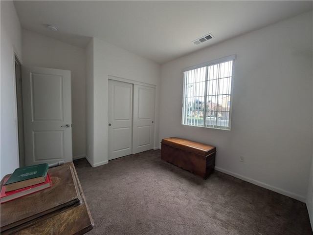 bedroom with baseboards, visible vents, carpet floors, and a closet