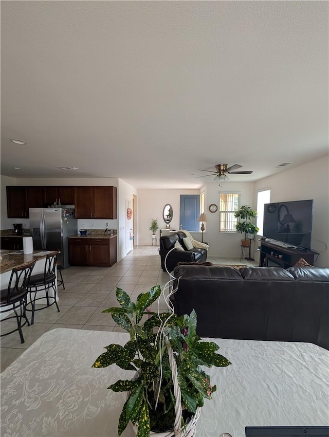 living room featuring light tile patterned floors and ceiling fan