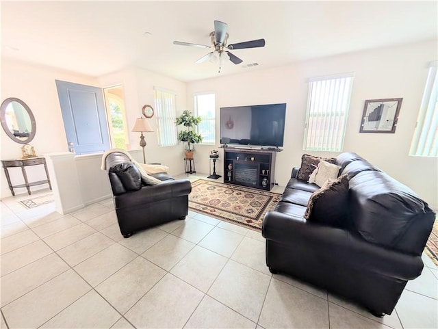 living area featuring light tile patterned flooring, visible vents, and ceiling fan