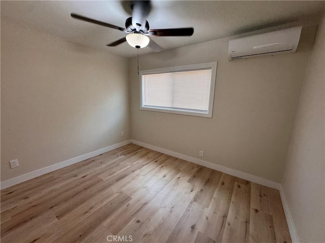 1716 Paloma St, Barstow, CA 92311 - spare room featuring a wall unit AC, wood finished floors, baseboards, and a ceiling fan