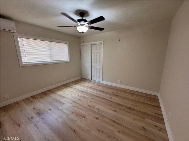1716 Paloma St, Barstow, CA 92311 - unfurnished bedroom with an AC wall unit, wood finished floors, baseboards, and a closet