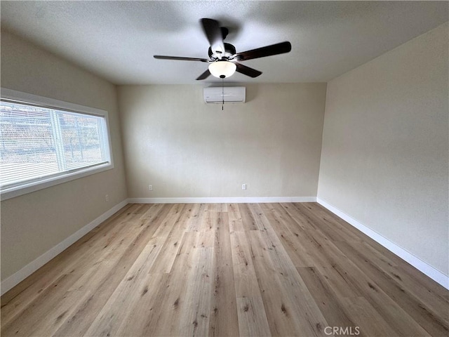 1716 Paloma St, Barstow, CA 92311 - unfurnished room featuring ceiling fan, light wood-type flooring, a wall unit AC, and baseboards