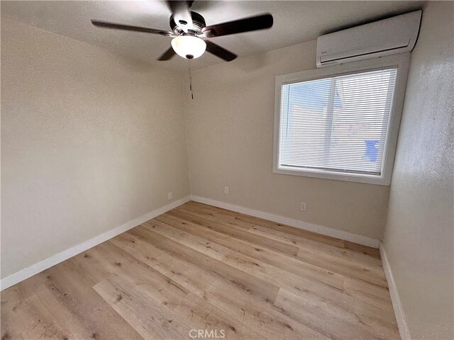 1716 Paloma St, Barstow, CA 92311 - unfurnished room featuring an AC wall unit, wood finished floors, ceiling fan, and baseboards